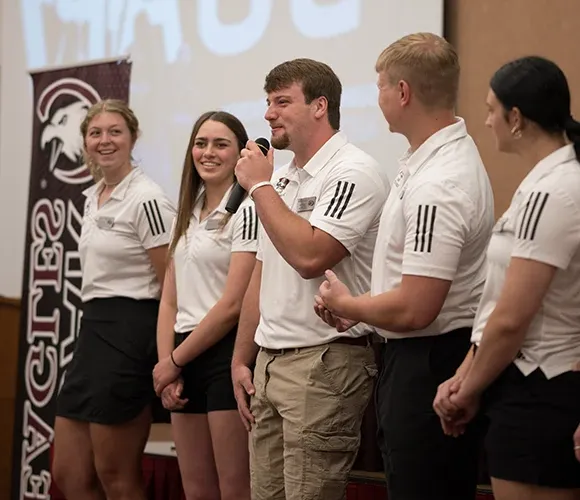 Several students speaking to an audience